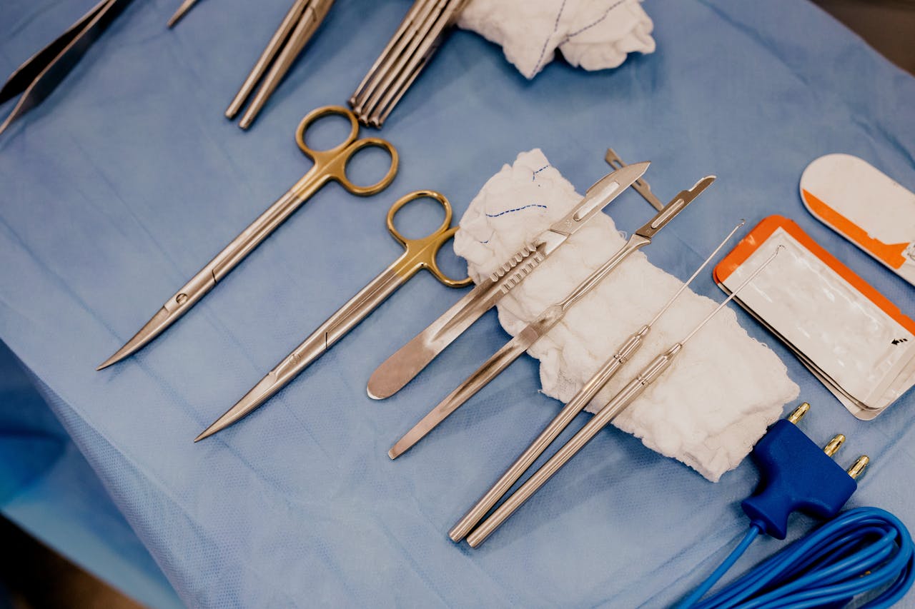 High angle view of surgical instruments on blue drapes, ready for use in the operating room.